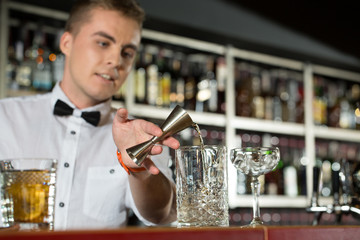 True art. Horizontal shot of young bartender making a drink.