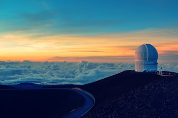 Single telescope on top of mountain above the clouds