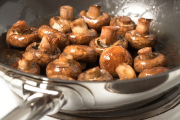 mushrooms beeing fried in a pan