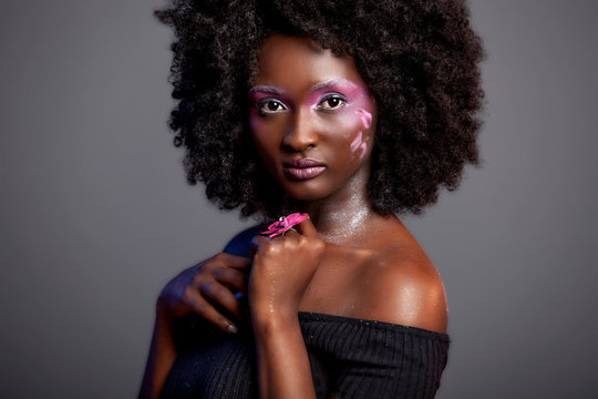  Afro and Flower beauty with big black hair smooth dark skin  does stunning poses for studio photography shoot 