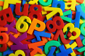 Plastic magnetic letters and numbers as background, top view