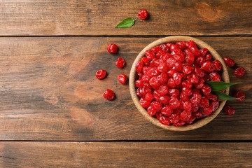 Bowl of tasty cherries on wooden background, top view with space for text. Dried fruits as healthy food