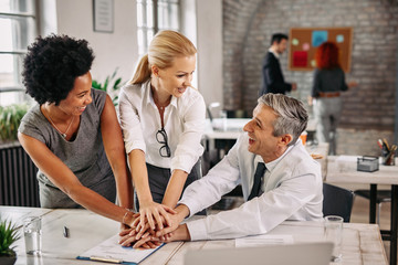 Obraz premium Multi-ethnic group of business people gathering hands in unity.