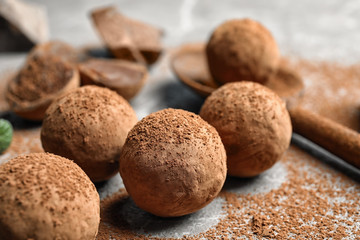 Delicious raw chocolate truffles on grey background