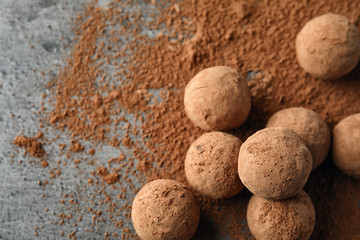 Delicious raw chocolate truffles on grey background, top view with space for text