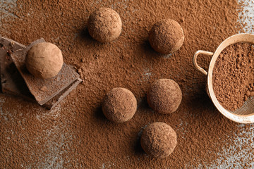 Flat lay composition with chocolate truffles powdered with cacao on table