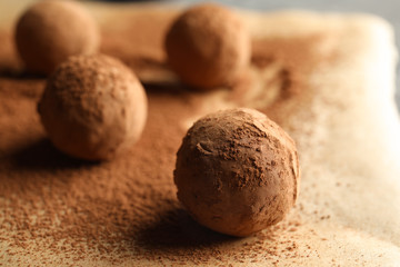 Tasty chocolate truffles on parchment paper, closeup