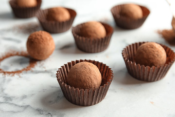 Tasty raw chocolate truffles on marble background