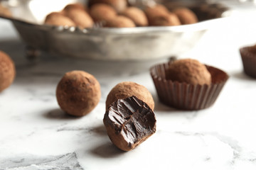 Tasty raw chocolate truffles on marble table