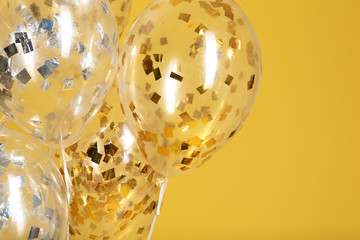 Balloons with sparkles on color background, closeup. Space for text