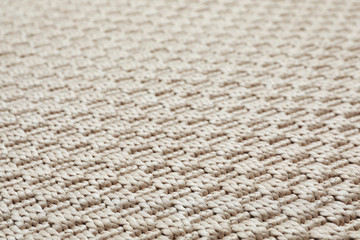 Beige woven carpet texture as background, closeup