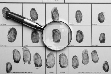 Magnifying glass and criminal fingerprint card, top view