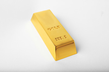 Precious shiny gold bar on white background