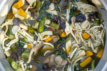 Mushroom soup boiled in big pot, Thai style food. Street food in local market, Thailand, closeup