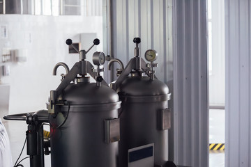 Manometer on the cylinder with gas in and hop dispenser in modern brewery. Close-up view