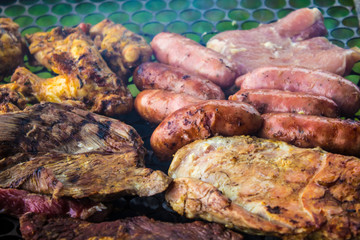 Assorted delicious grilled meat  over the coals on a barbecue.