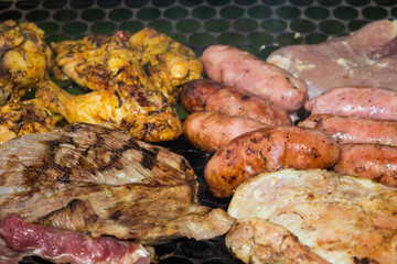 Assorted delicious grilled meat  over the coals on a barbecue.