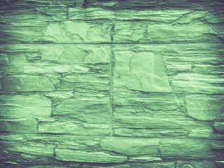 Facade tiles imitating stone texture in green tones.