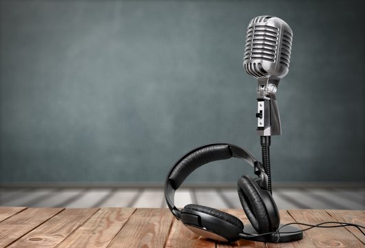 Retro style microphone and headphones on  background