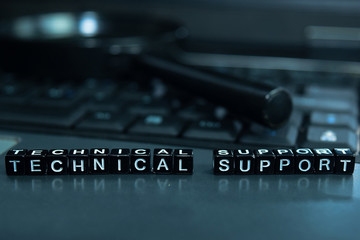 Technical Support text wooden blocks in laptop background. Business and technology concept