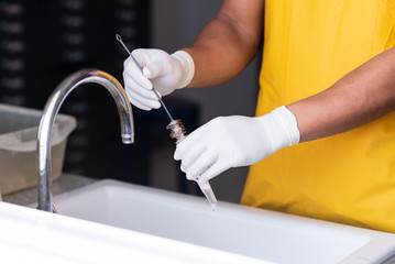 Close up worker hand washing and brushing test tube in laboratory room.Scientist hand holding and cleaning blood test tube in biological lab room. © arcyto