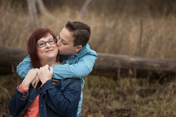 teen boy kissing mom on the cheek