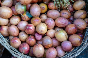 Raw passion fruit on the bamboo or wooden basket in traditional street market in Ubud, Bali, Indonesia , closeup