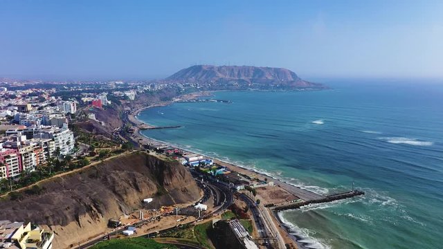 Aerial view of Lima's shoreline including the districts of Barranco and Chorrillos, with "Morro Solar" on the background. Clear and bright day, travel and destinations concept.