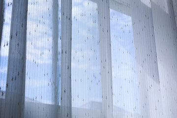 white drapery curtain hanging on the window