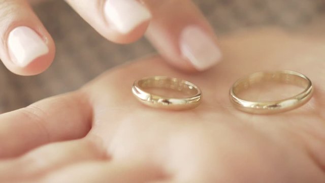 Extreme close up of a wedding ring caressed by beautiful woman hands