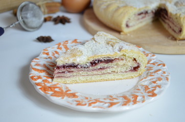 Homemade pie with cherry berries, cup of tea and fork on white wooden table. with ingredients for cooking, cinnamon, anise, icing sugar, topping. homemade baking. copy space. Top view.