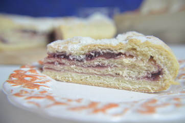 Homemade pie with cherry berries, cup of tea and fork on white wooden table. with ingredients for cooking, cinnamon, anise, icing sugar, topping. homemade baking. copy space. Top view.