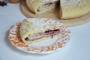 Homemade pie with cherry berries, cup of tea and fork on white wooden table. with ingredients for cooking, cinnamon, anise, icing sugar, topping. homemade baking. copy space. Top view.