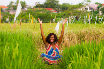 young beautiful and happy black afro American woman sitting at rive field outdoors practicing yoga relaxation and meditation enjoying holidays