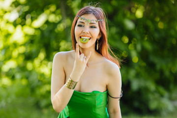 Beautiful young asian woman with slice of kiwi in mouth