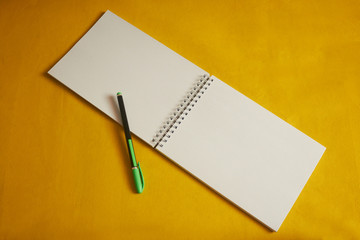 Notebook with pen on a yellow background for notes in a notebook. Office for school and office.