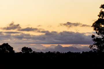 Rolling cloudscape over silhouette horizon at dusk.