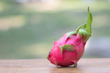 Juicy pink pitaya on wooden background