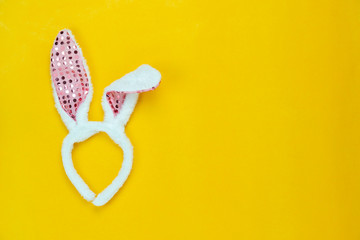 Table top view shot of decorations Happy Easter holiday background concept.Flat lay  beautiful costume bunny ear on modern rustic yellow paper.Copy space for creative design for mock up & template.