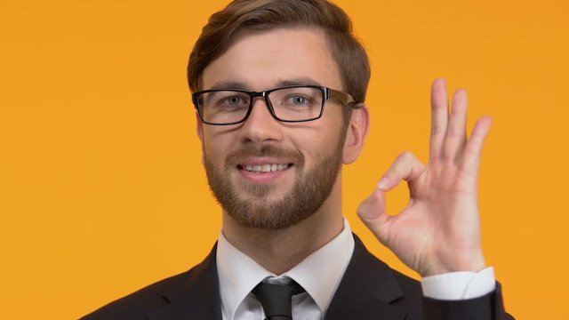 Smiling man showing ok sign, satisfied with good service, successful deal