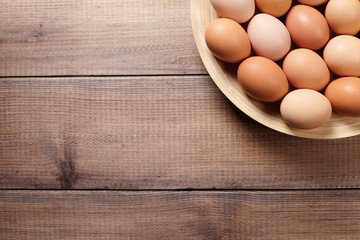  Eggs on the plate on wooden table. Top view. Background with copy space.
