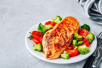 Healthy lunch bowl with roasted chicken, grilled tomatoes and broccoli