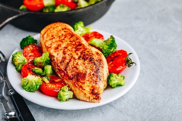 Healthy lunch bowl with roasted chicken, grilled tomatoes and broccoli