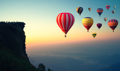 Obraz premium Colorful hot air balloons flying over the mountain.