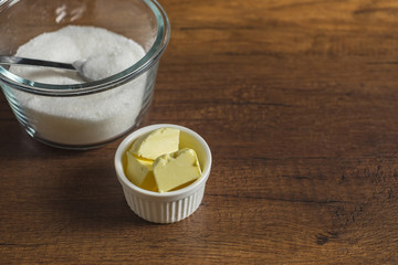 Butter in small cut portion ready for cooking with sugar in a glass bowl.