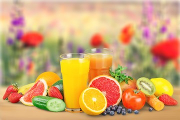 Glasses of fresh juice and fruits with vegetables and measuring tape