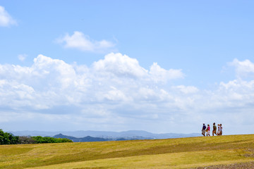 Caucasian adult men and women walking downhill on countryside landscape
