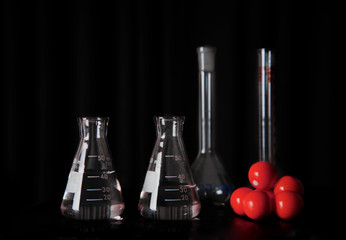 research science glass flasks with water and red chemical molecular structure still life education black background