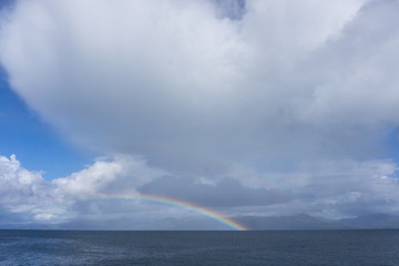 a beautiful rainbow looming over the bay over the sea in Scotland