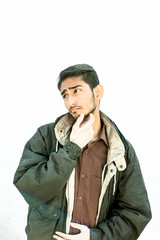 Portrait shot of young teenager beard wearing a maroon colored shirt and a black colored jacket expressing doubtfulness on his face and thinking about something isolated on white.